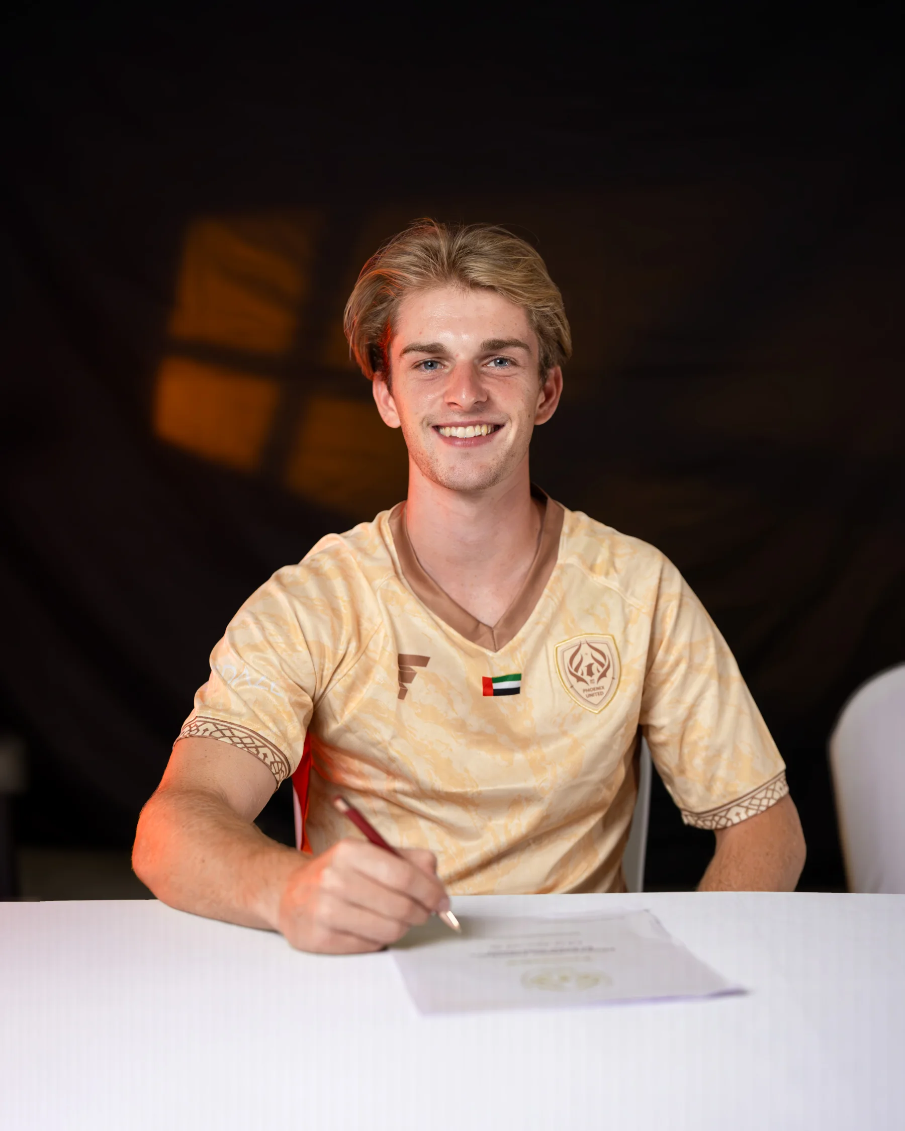 A player signing at Phoenix United